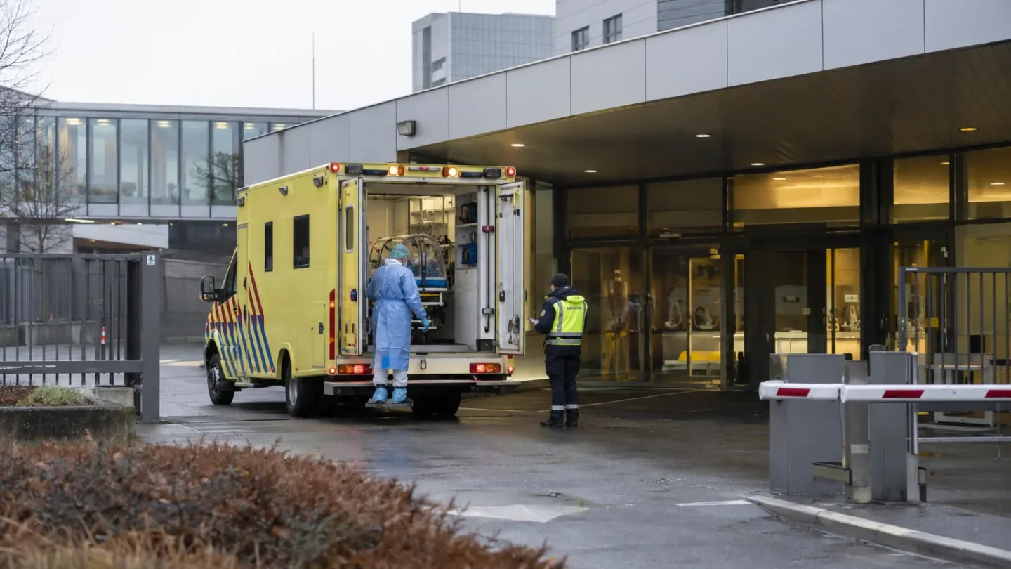 Gespecialiseerde ambulance bij een moderne Nederlandse ziekenhuisingang als conceptbeeld bij de opname van een ebolapatiënt