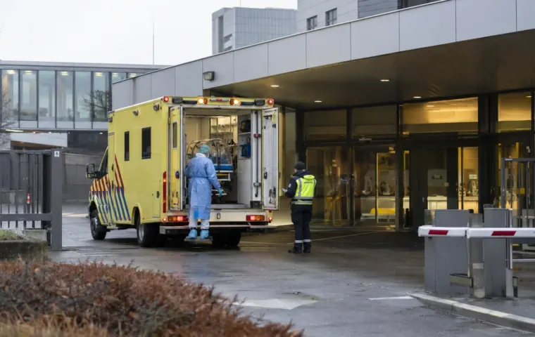 Gespecialiseerde ambulance bij een moderne Nederlandse ziekenhuisingang als conceptbeeld bij de opname van een ebolapatiënt