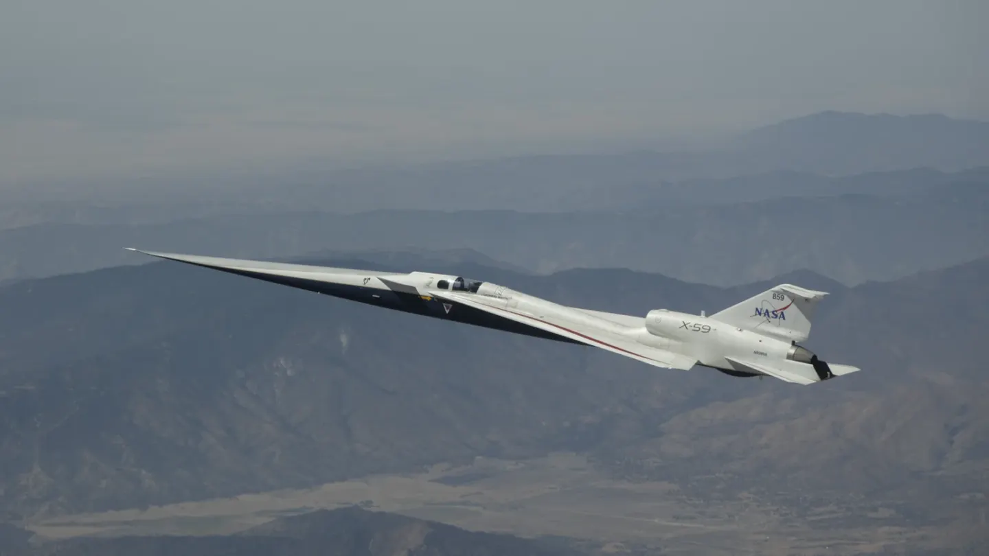 NASA’s langgerekte X-59 vliegt boven het bergachtige landschap van de Mojavewoestijn